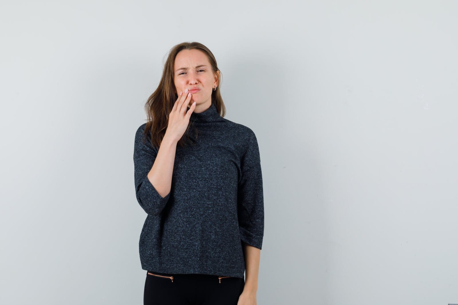 A young woman holding her hand to her mouth