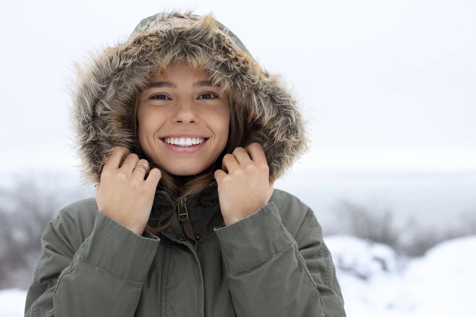 A smiling young woman in a fur-lined winter hood
