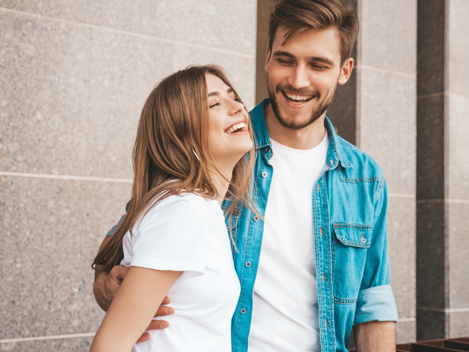 A young couple laughing together close up